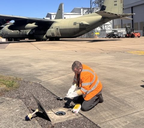 Practical airfield lighting training with testing equipment beside an aircraft